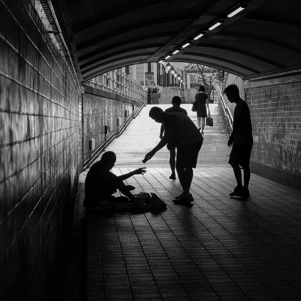person helping homeless in tunnel